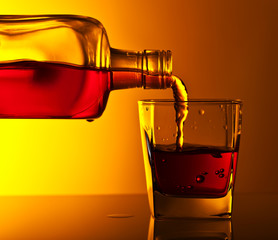 bottle and glass of whiskey on a glass table