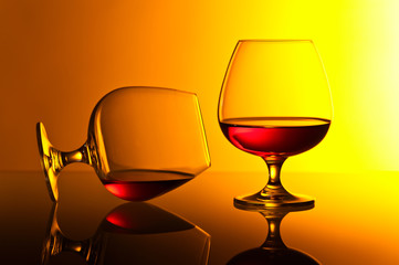 snifters of brandy on yellow background