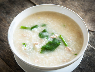 Thai style of rice gruel in bowl on wood background