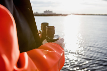 Fisherman on the boat with binoculars in hand.