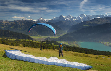Paraglider taking off in front of spectacular Swiss scenery, Bernese Oberland, Switzerland. - 127703312