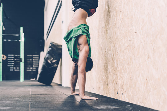 Young male cross trainer doing handstand in gym - Powered by Adobe