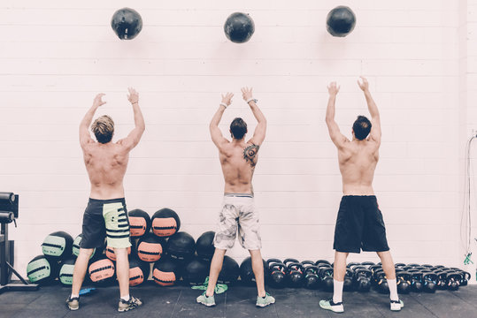 Three men train with medicine balls