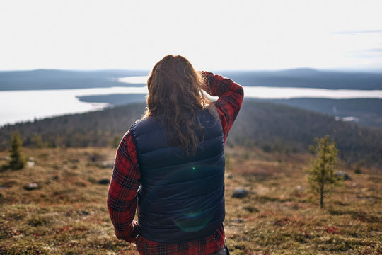 Hiker looking out to lake, Keimiotunturi, Lapland, Finland