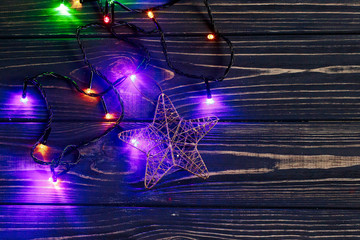 christmas garland lights and golden star on stylish black rustic