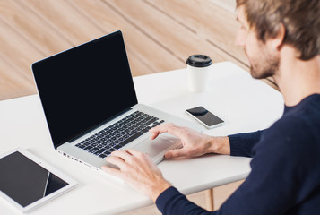 Business man using laptop computer. Male hand typing on laptop keyboard. Blank computer monitor