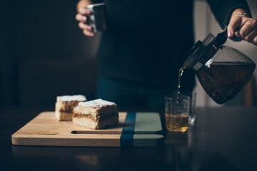Woman hands pours tea
