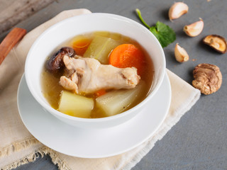 Fresh vegetable marrow soup in white bowl on wooden table