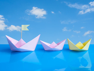 Naklejka premium Leadership concept, Craft of paper boat (Origami bird) on blue b