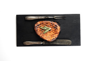 grilled beef steak on a black slate board. On a white background
