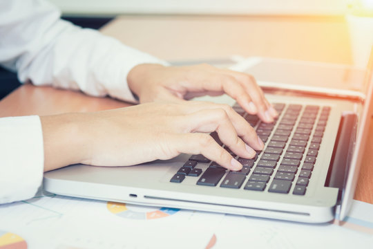 Closeup of business woman hand typing on laptop keyboard