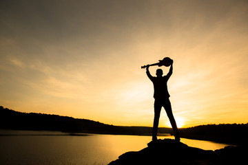 silhouette of musician with guitar at sunset or sunrise