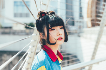 Half length portrait of young beautiful asian millennial woman outdoor in the city, overlooking...