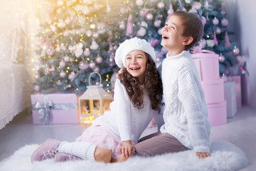 Fototapeta na wymiar Happy children girl and boy waiting for Christmas, winter holidays