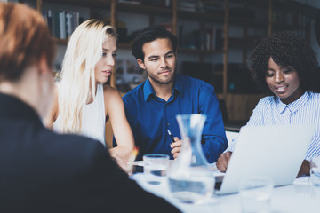 Young team of coworkers making great work discussion in modern office.Hispanic businessman talking with partners.Business people meeting concept.Horizontal, blurred background.