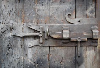 Massive metal lock on dark wooden door
