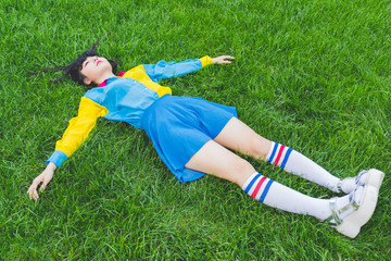 Fototapeta na wymiar young beautiful asian millennial woman nonconformist laying on the grass relaxing - sleeping, death, relaxing concept