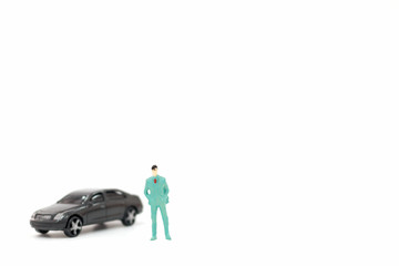 Miniature figures of man and car on white background