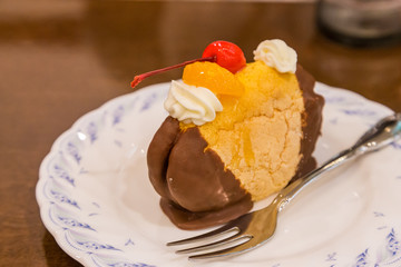 Chocolate cream puff with peach and cherry topping
