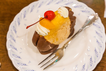 Chocolate cream puff with peach and cherry topping