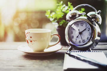 SStart up concept.Coffe cup,alarm clock,notebook.morning coffee