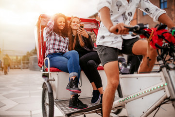 Young women sitting on tricycle and looking at mobile phone