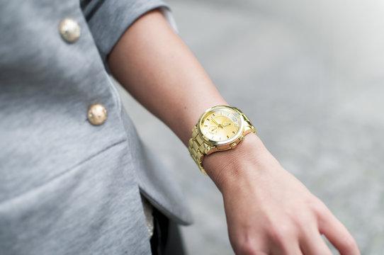 Fashion woman with golden watch on hand