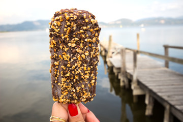 chocolate ice cream / Hand holding bitten ice cream / Ice Cream holded by hand /  hand holding ice cream / ice cream