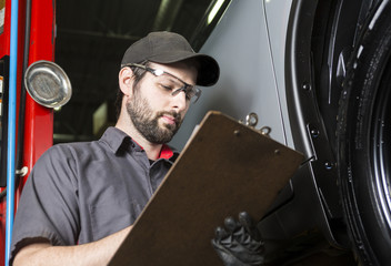Obraz na płótnie Canvas Mechanic working on car in his shop