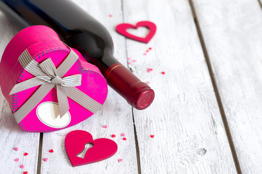 St. Valentine's setting with bottle of red wine and heart presen