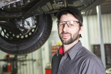 Mechanic working on car in his shop