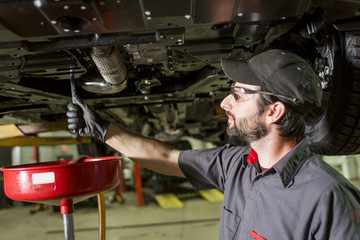 Mechanic working on car in his shop