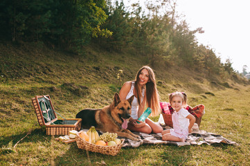 mother and daughter at a picnic with a dog