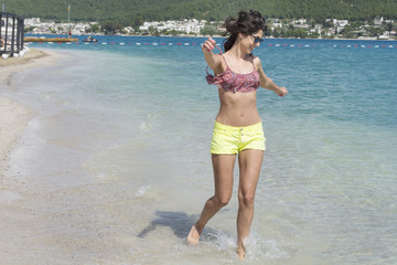 Portrait of happy young woman Jumping In The Air On a Tropical Beach.Summer holiday