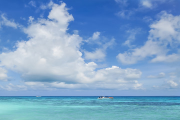 Fototapeta na wymiar Tourist boat in the sea with cloudy blue sky