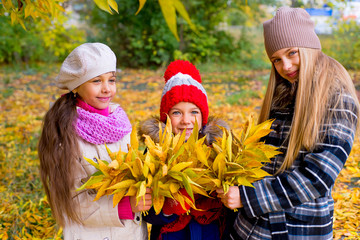 group of girls in autumn park with leafs