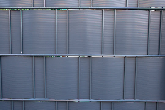 Modern steel fencing texture with black or anthracite woven plastic panels for privacy