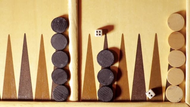 Backgammon board with rolling dice, shot from above.