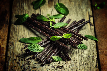 Dark chocolate with mint, vintage wood background, selective foc