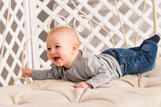 Adorable baby boy in sunny bedroom. Newborn child relaxing. Family morning at home. New born kid during tummy time.
