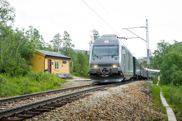 Naklejka premium Flamsbana railway train arriving at small rural station, Norway.