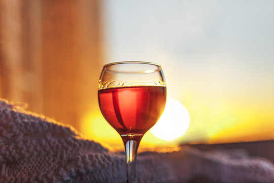 Red wine and white blanket.Sunny evening lights.Toned bokeh image.