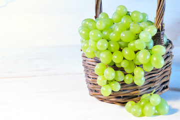Green grape in basket on wooden table