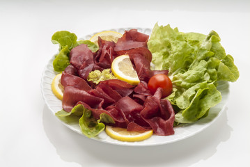 bresaola insalata pomodoro limone in piatto primo piano