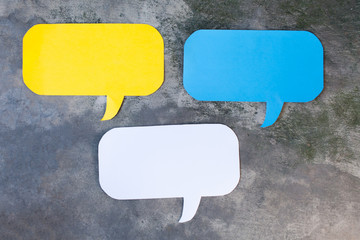 Three of Yellow, Blue and White Speech Bubbles Over Gray Grunge Background - Balloon speech bubble concept