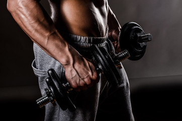 Powerful Body of Athlete Bodybuilder Posing with Dumbbells