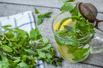 Mint tea with lemon, mint and tea strainer. Winter warming soothing drink.