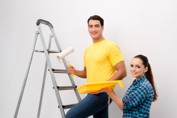 Young couple painting wall at home