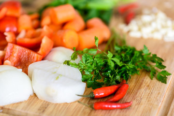 Onion, Carrots, Bell Peppers, Garlic And Parsley Raw Vegetables Ingredients On Wood