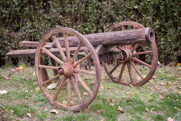 Fototapeta na wymiar Old antique cannon with wooden wheels on grass.